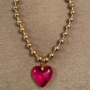 Golden necklace with a pink heart